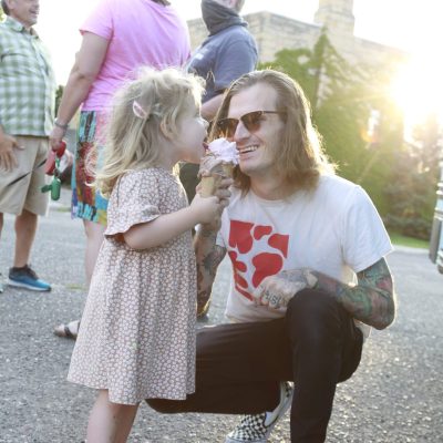 Father and his child eating ice cream at a park.